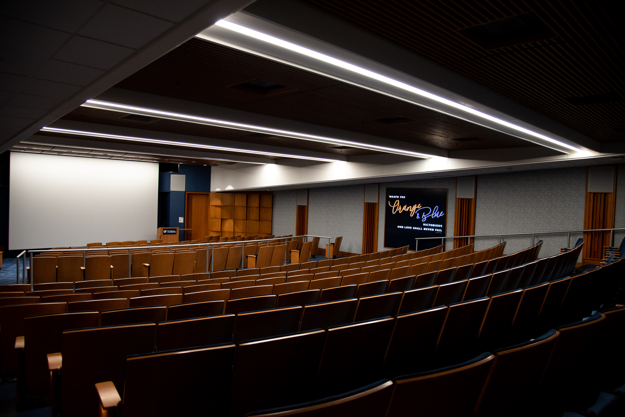 Rows of auditorium seating facing a projector screen inside the Reitz Union Auditorium.