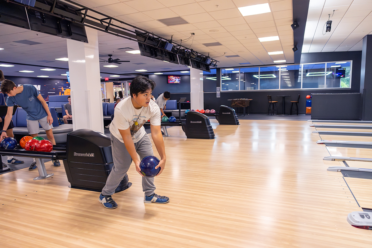 Student prepares to roll a bowling ball at a lane inside the Reitz Union Game Room.
